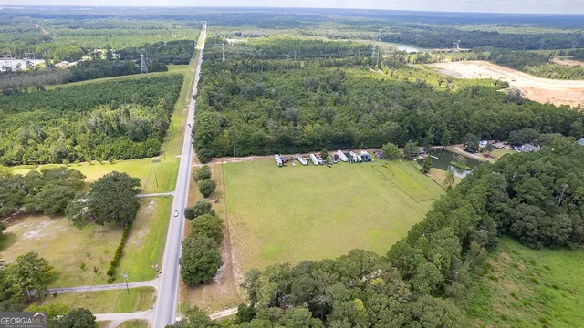 an aerial view of a house with a yard and trees all around