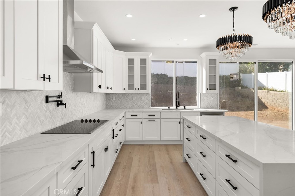 3704 Howe Street Corona, CA 92881 - Photo 4 of 26 a kitchen with stainless steel appliances granite countertop a stove a sink and a refrigerator with white cabinets