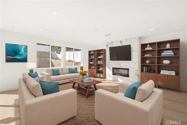 a living room with furniture a fireplace a flat screen tv and a couch