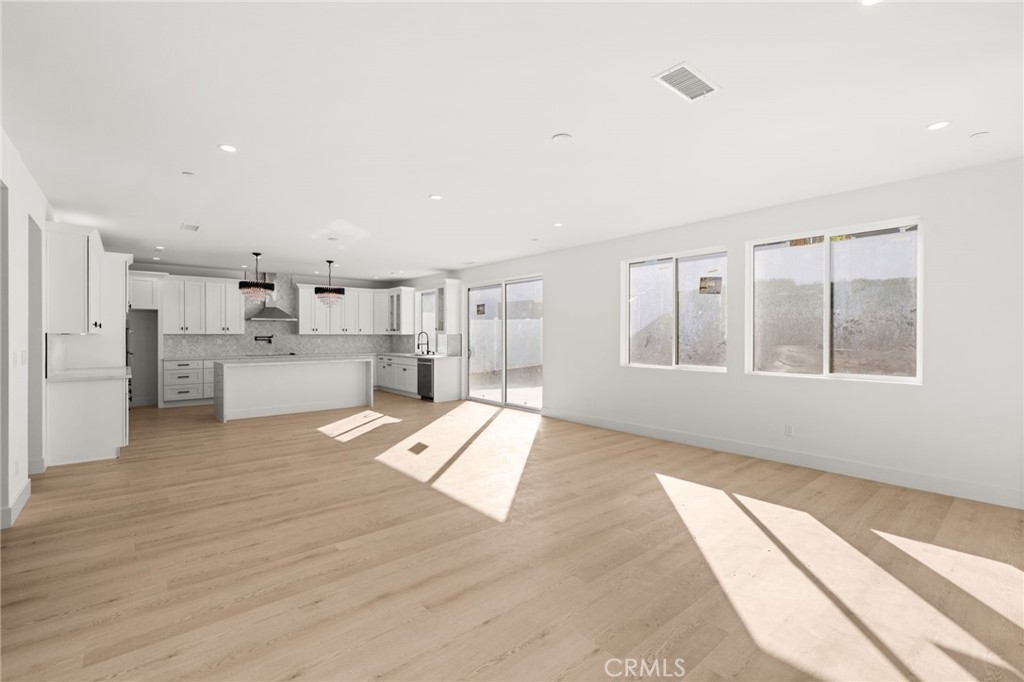 3704 Howe Street Corona, CA 92881 - Photo 6 of 26 a view of large kitchen with stainless steel appliances kitchen island large window and wooden floor