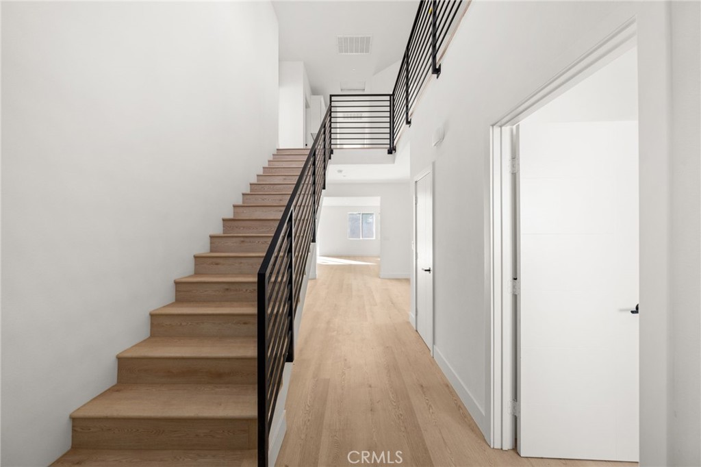 3704 Howe Street Corona, CA 92881 - Photo 9 of 26 a view of staircase with wooden floor and white walls