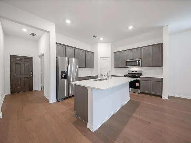 a kitchen with kitchen island granite countertop stainless steel appliances and view living room