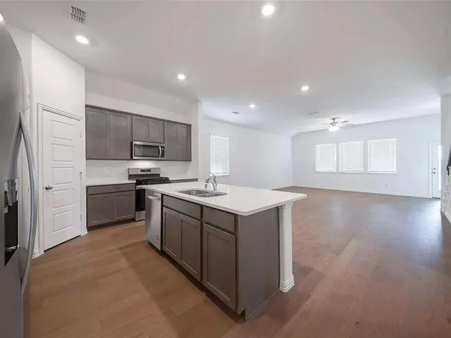 a kitchen with a stove and a wooden floor