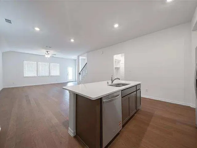 a view of an empty room with a kitchen