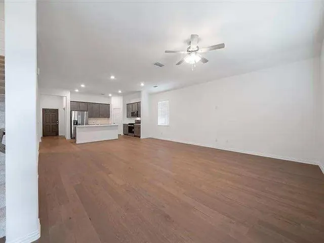 a view of a livingroom with furniture and a chandelier fan