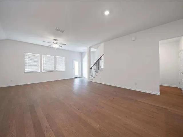 an empty room with a window and a fan