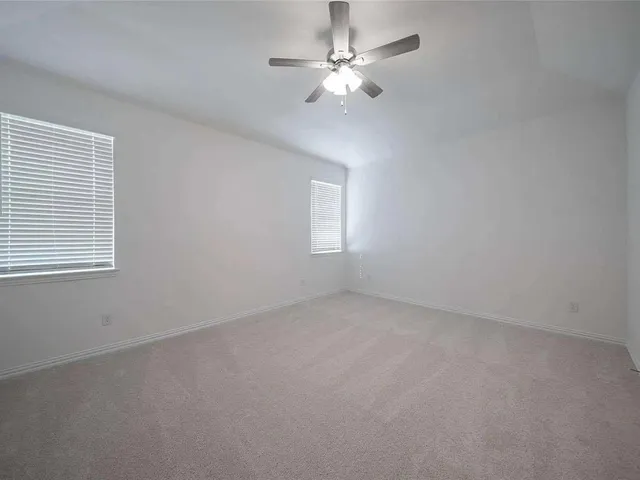 an empty room with chandelier fan