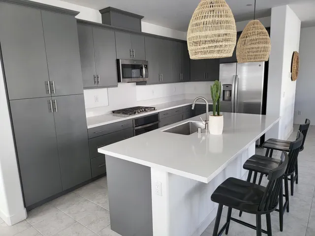 a kitchen with stainless steel appliances a table chairs and a refrigerator