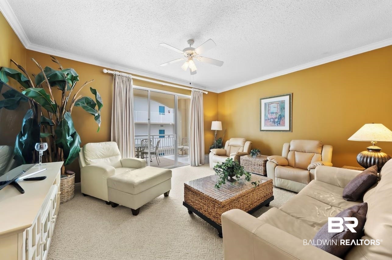 27770 Canal Road, Unit 2502 Orange Beach, AL 36561 - Photo 6 of 55 Carpeted living room featuring a textured ceiling, crown molding, and ceiling fan