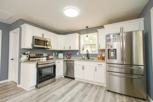 a kitchen with stainless steel appliances a refrigerator sink and microwave