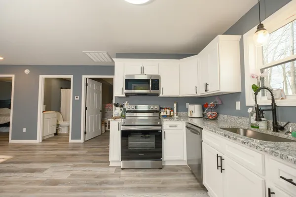 a kitchen with stainless steel appliances granite countertop a stove and a sink