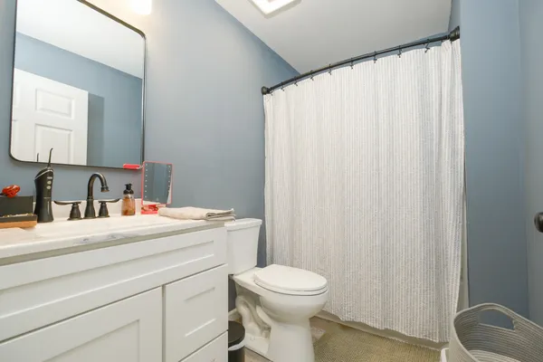 a bathroom with a sink vanity mirror and toilet