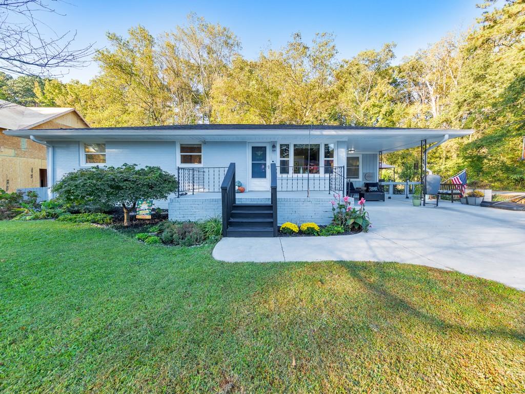 a front view of a house with a yard and potted plants