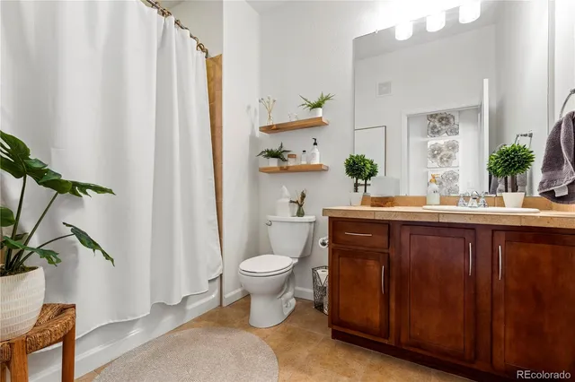 a bathroom with a granite countertop sink toilet and a mirror