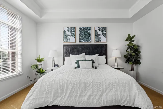 a bedroom with a large bed and a potted plant