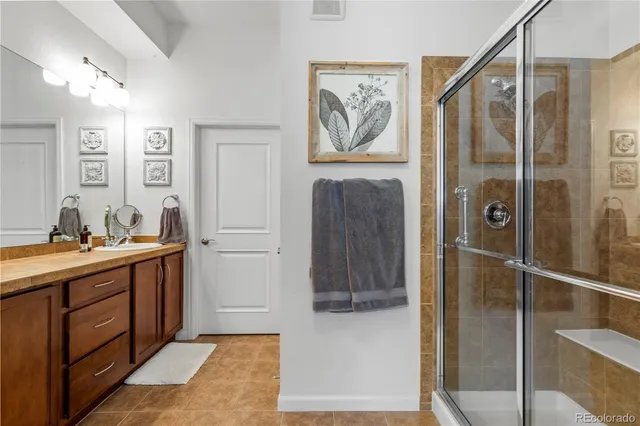 a bathroom with a mirror a double vanity sink and glass door