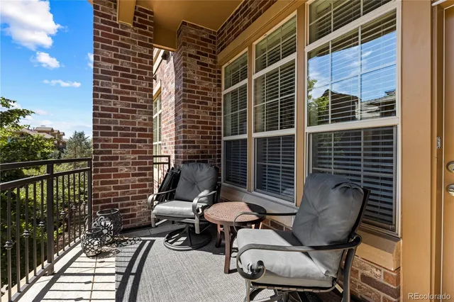 a view of a balcony with chairs and a gate