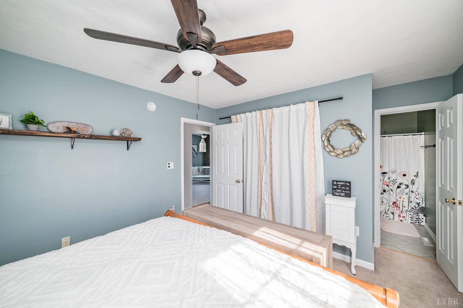 1077 Terrace View Road Goode, VA 24556 - Photo 17 of 54 a bedroom with a large bed and a chandelier fan