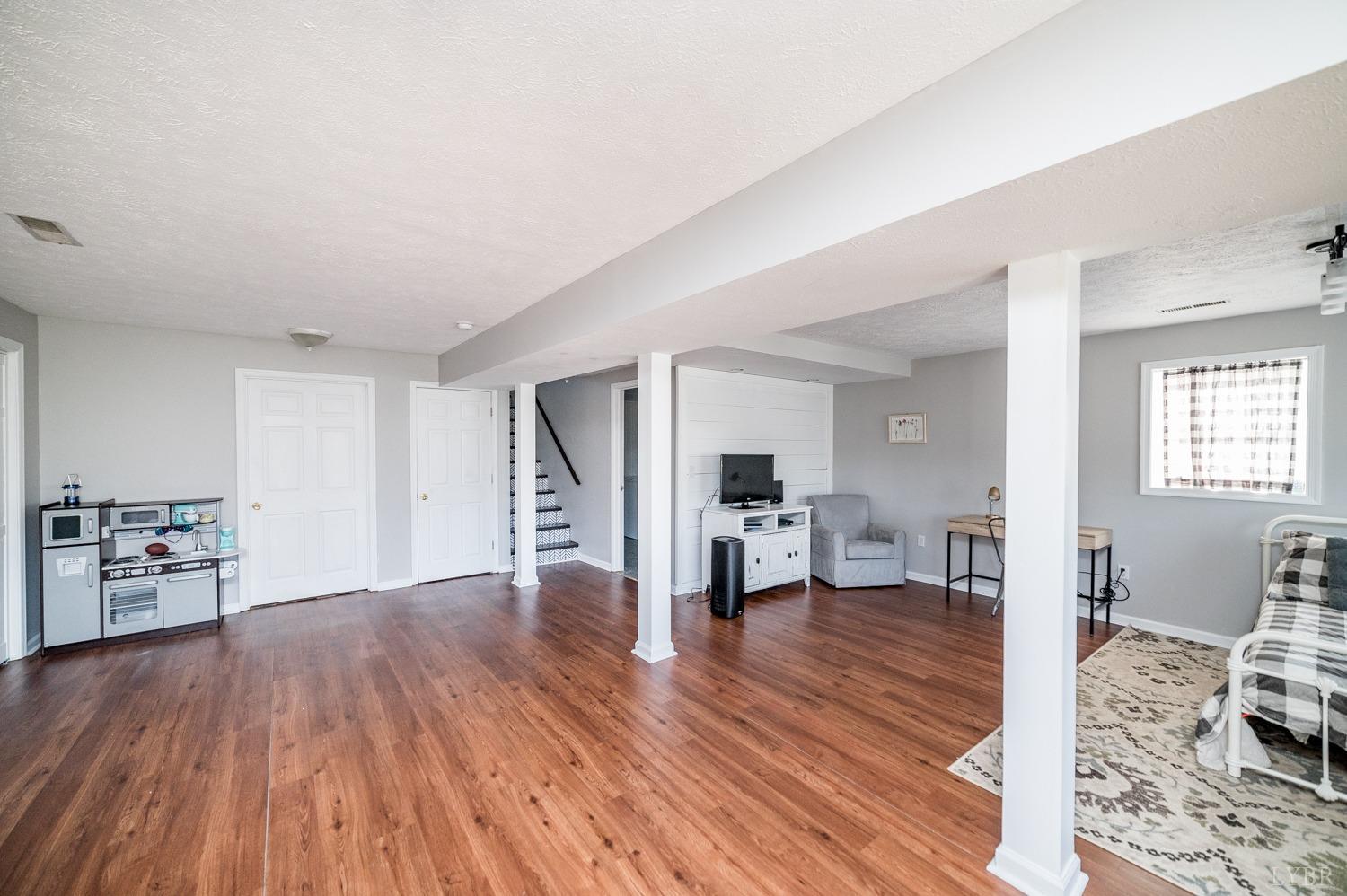 1077 Terrace View Road Goode, VA 24556 - Photo 21 of 54 a view of a living room filled with furniture and wooden floor
