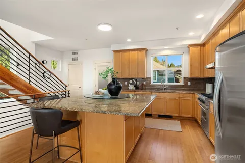 a kitchen with stainless steel appliances granite countertop a sink a stove and a refrigerator