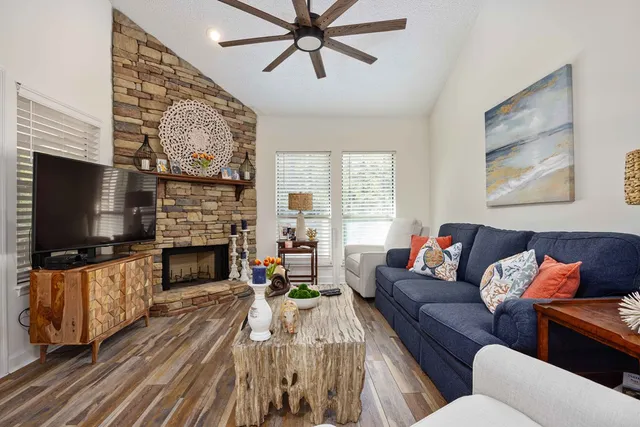 a living room with furniture a flat screen tv and a fireplace