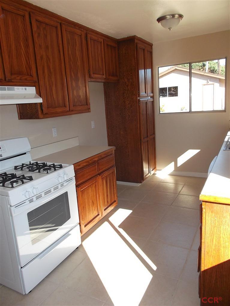 404 North A Street Lompoc, CA 93436 - Photo 4 of 15 a kitchen with wooden cabinets and a stove top oven