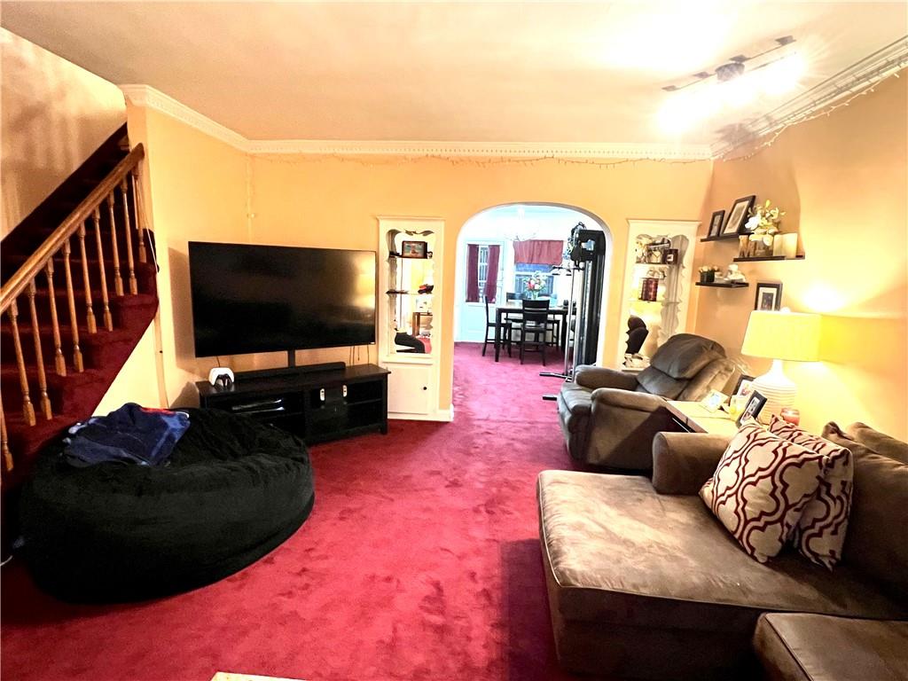 75-06 Utopia Parkway Queens, NY 11366 - Photo 2 of 9 a living room with furniture and a flat screen tv