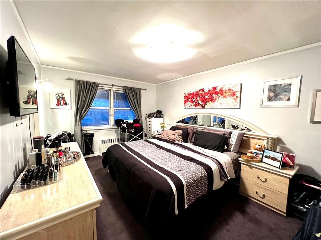 75-06 Utopia Parkway Queens, NY 11366 - Photo 5 of 9 a bed room with bed and a flat screen tv