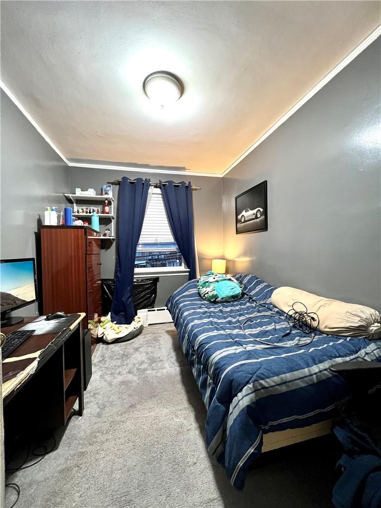 75-06 Utopia Parkway Queens, NY 11366 - Photo 6 of 9 a bedroom with a bed and a window