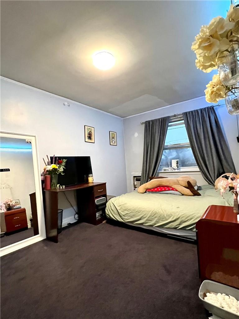 75-06 Utopia Parkway Queens, NY 11366 - Photo 7 of 9 a bed sitting in a room next to a window