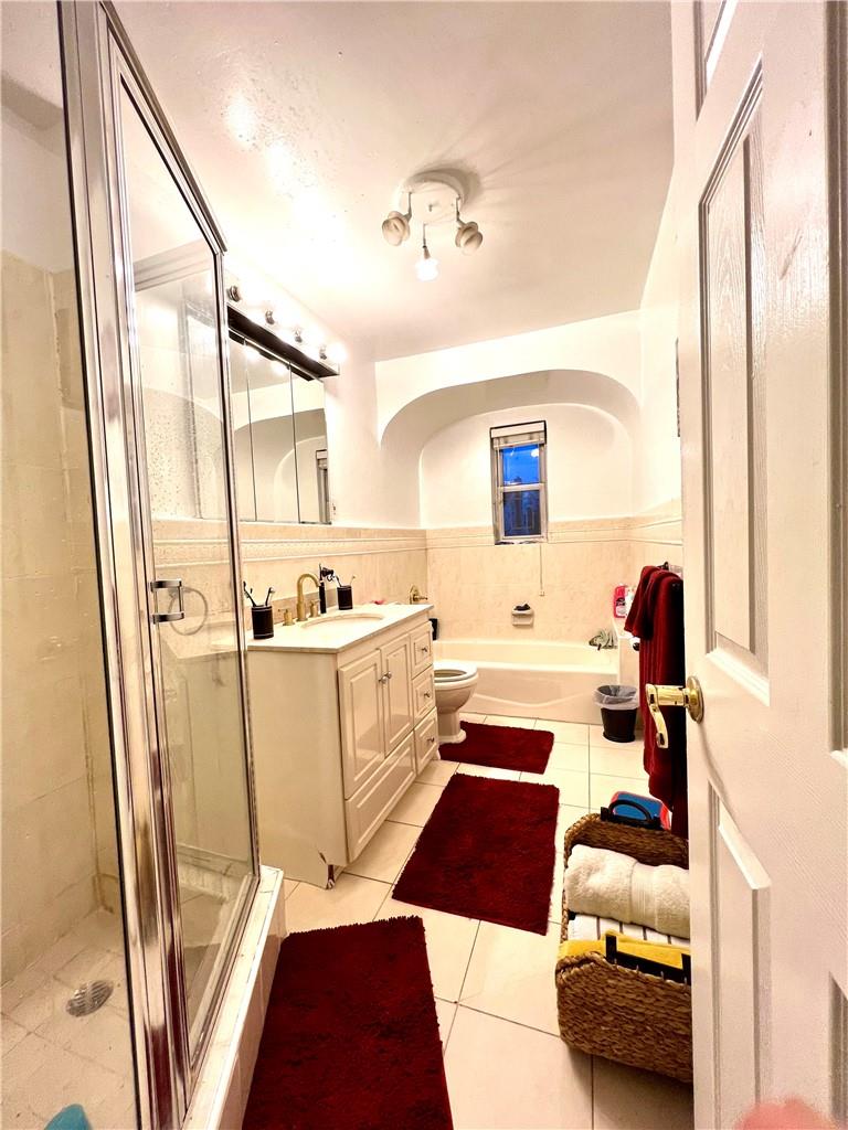 75-06 Utopia Parkway Queens, NY 11366 - Photo 8 of 9 a hallway with a couch and a window with wooden floor