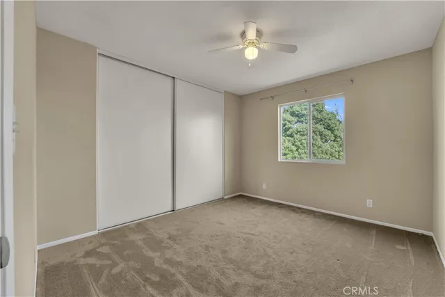 an empty room with windows and fan