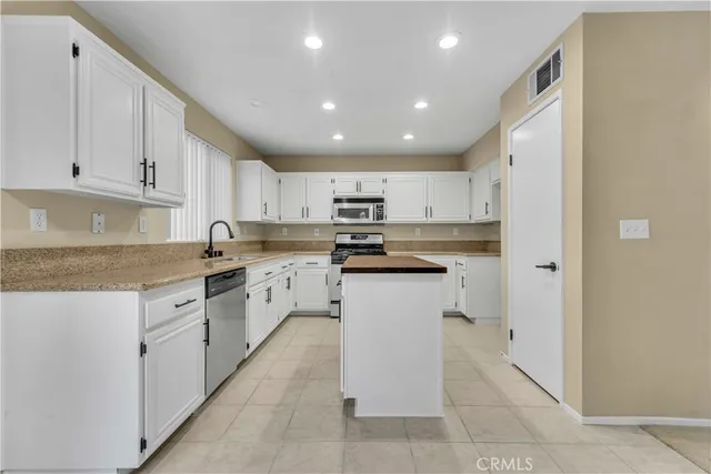 a kitchen with white cabinets and white appliances