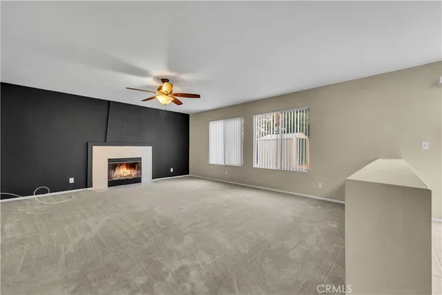a view of an empty room with a fireplace and a window