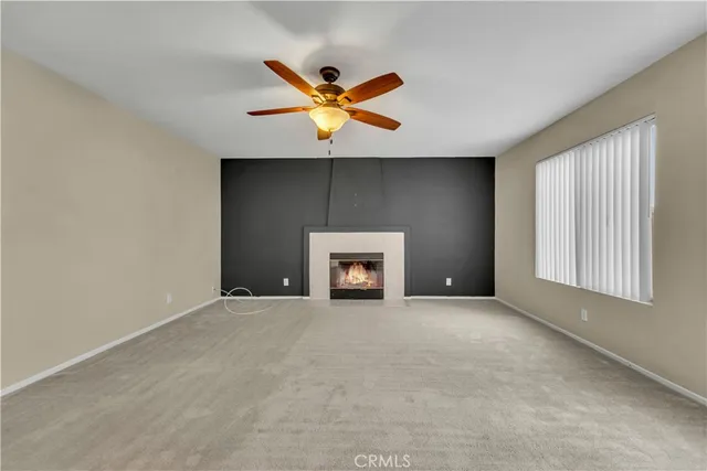a view of an empty room with a window and fireplace