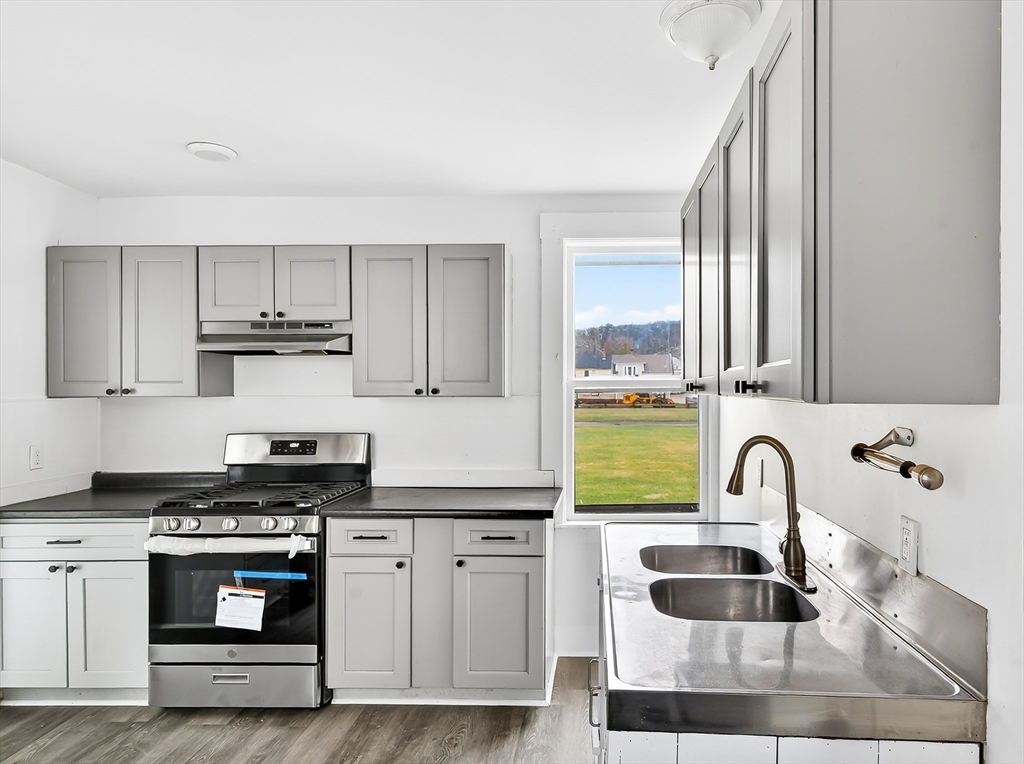 150 East Main Street Orange, MA 01364 - Photo 3 of 41 a kitchen with granite countertop a sink stainless steel appliances and cabinets