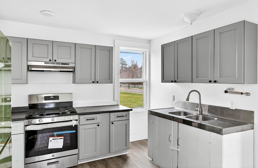 150 East Main Street Orange, MA 01364 - Photo 4 of 41 a kitchen with stainless steel appliances granite countertop a sink stove and cabinets