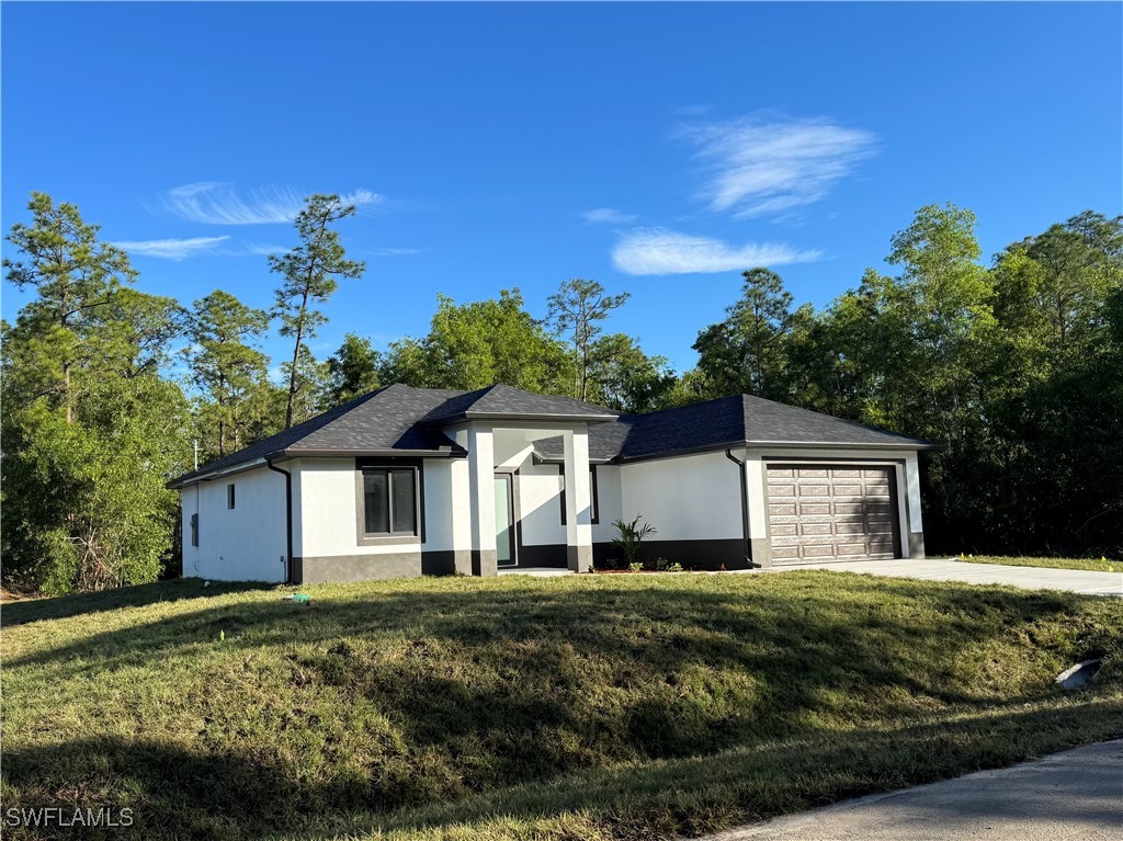 3701 East 3rd Street Lehigh Acres, FL 33936 - Photo 1 of 19 a front view of a house with a yard