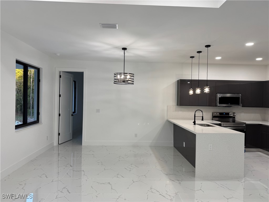 3701 East 3rd Street Lehigh Acres, FL 33936 - Photo 8 of 19 a kitchen with stainless steel appliances granite countertop a sink and a stove