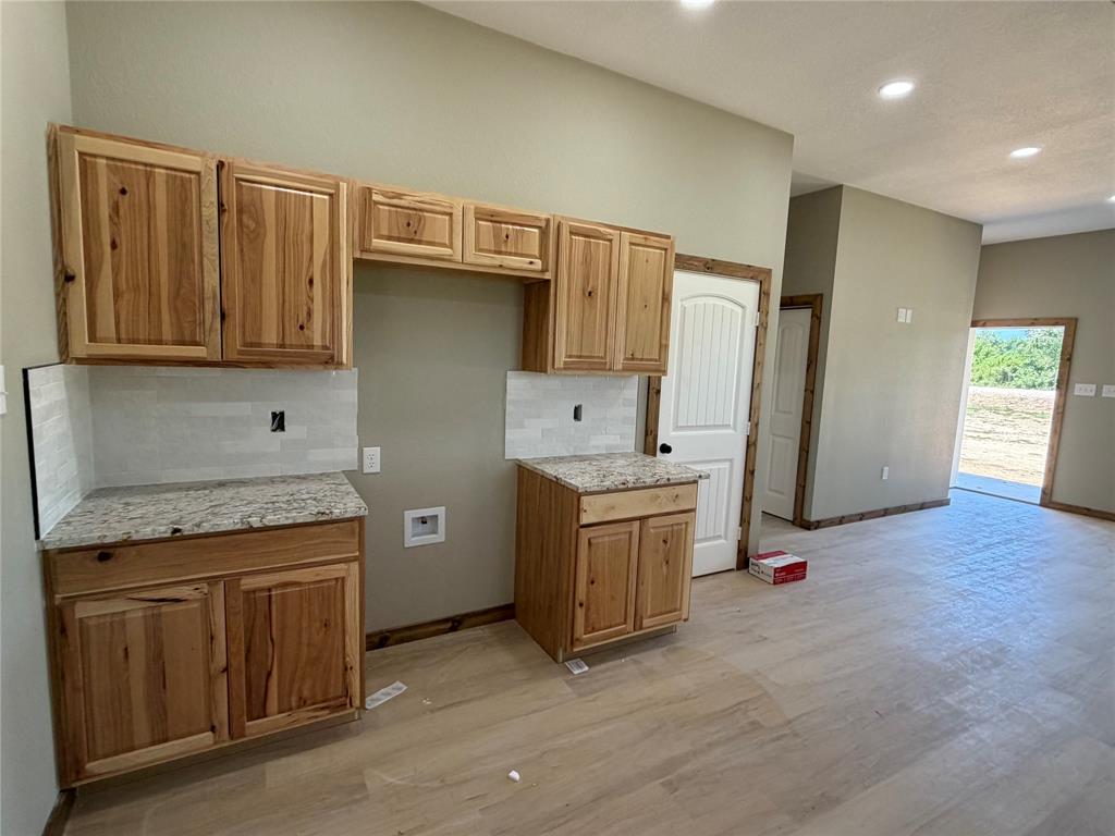 1040 Rays Way Weatherford, TX 76085 - Photo 16 of 23 Kitchen area featuring natural wood cabinetry, light-toned countertops, and a subway tile backsplash