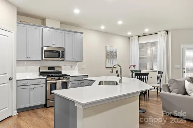 a kitchen with kitchen island a white counter top space a sink and appliances