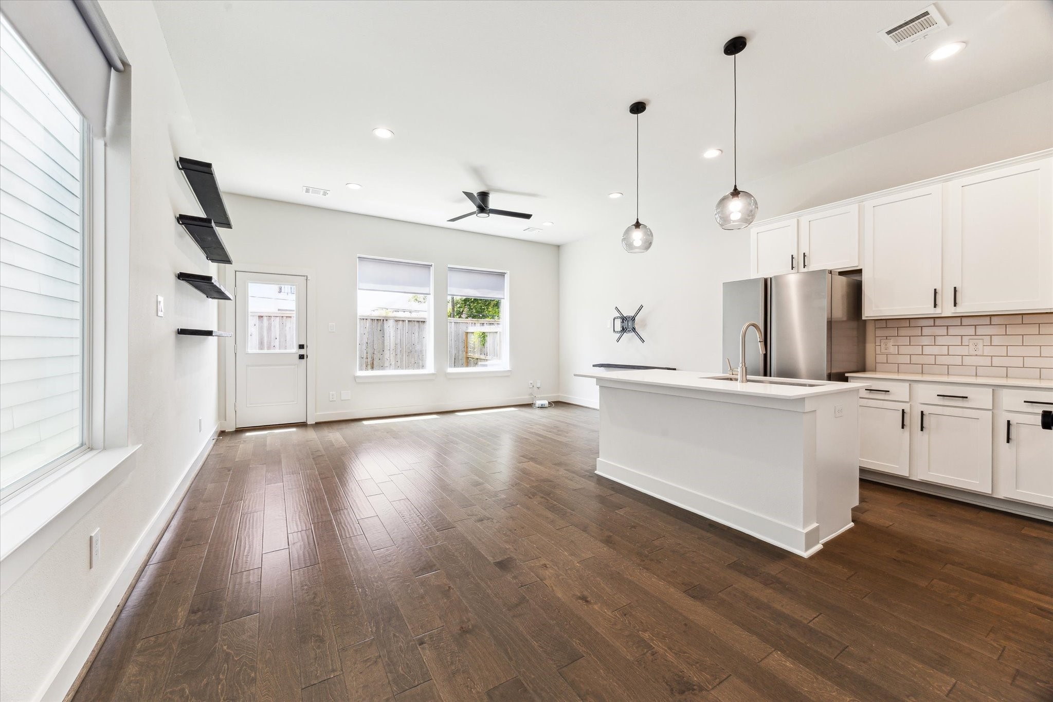 4155 Griggs Road Houston, TX 77021 - Photo 5 of 17 Bright and beautifully styled, this open living and dining space features rich hardwoods, sleek designer lighting, and an airy layout that flows effortlessly from the kitchen to the private backyard—ideal for entertaining or relaxing in comfort.
