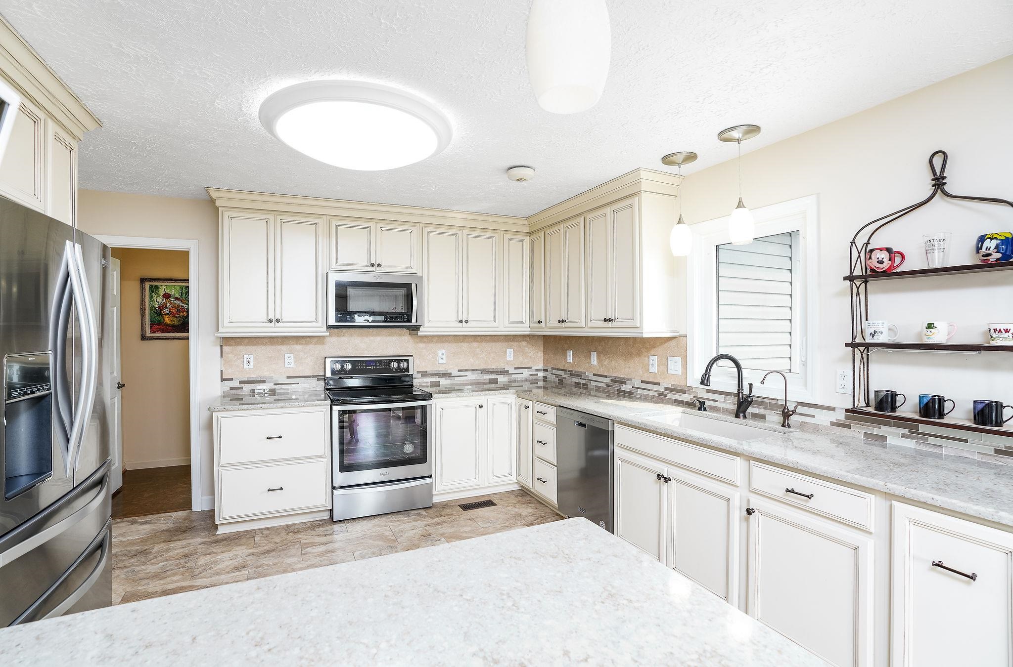 400 Quick's Mill Road Verona, VA 24482 - Photo 16 of 75 a kitchen with granite countertop a sink stainless steel appliances and white cabinets