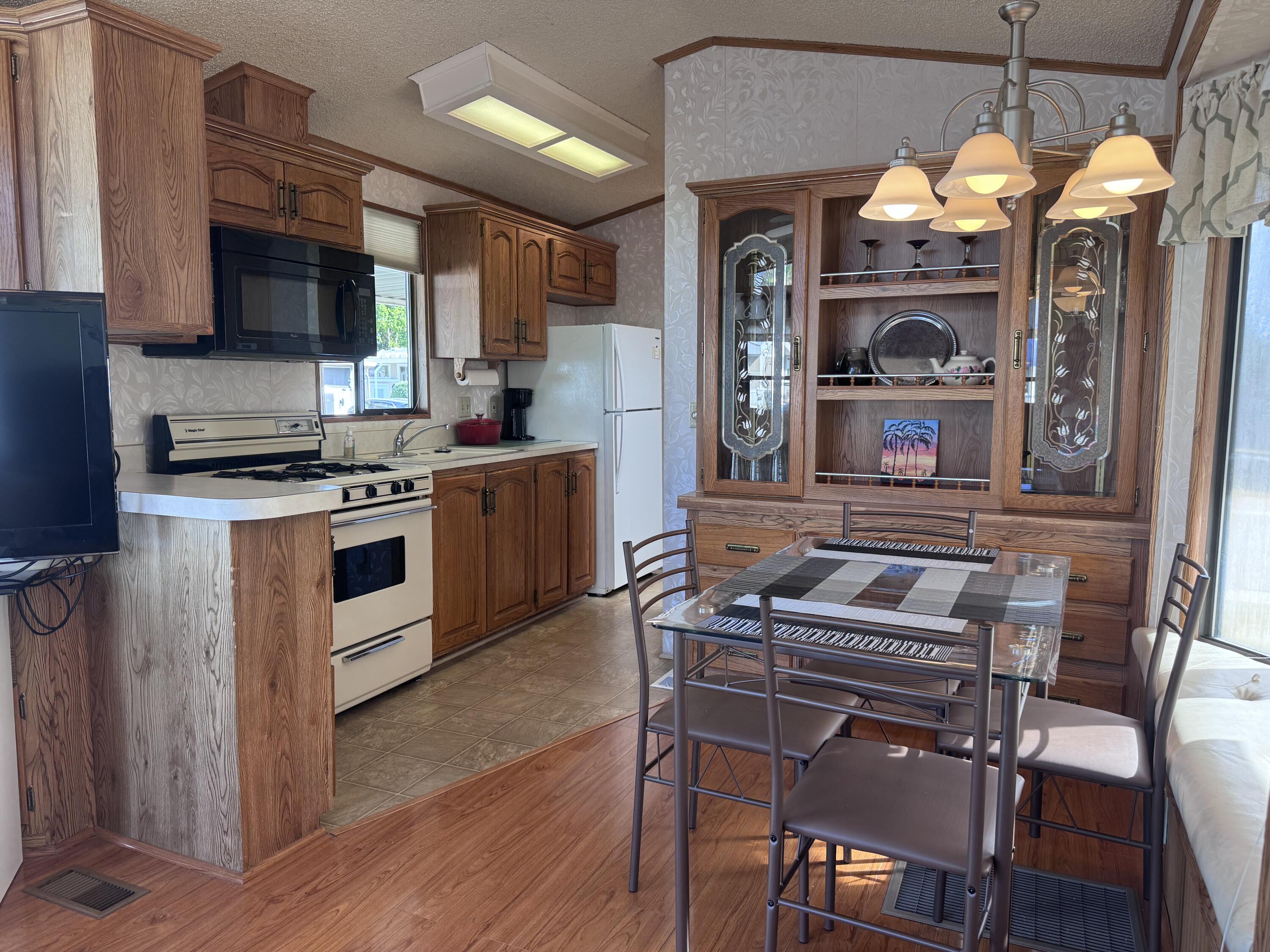 84136 Ave 44, Unit 178 Indio, CA 92203 - Photo 11 of 23 a kitchen with a stove a table and chairs in it