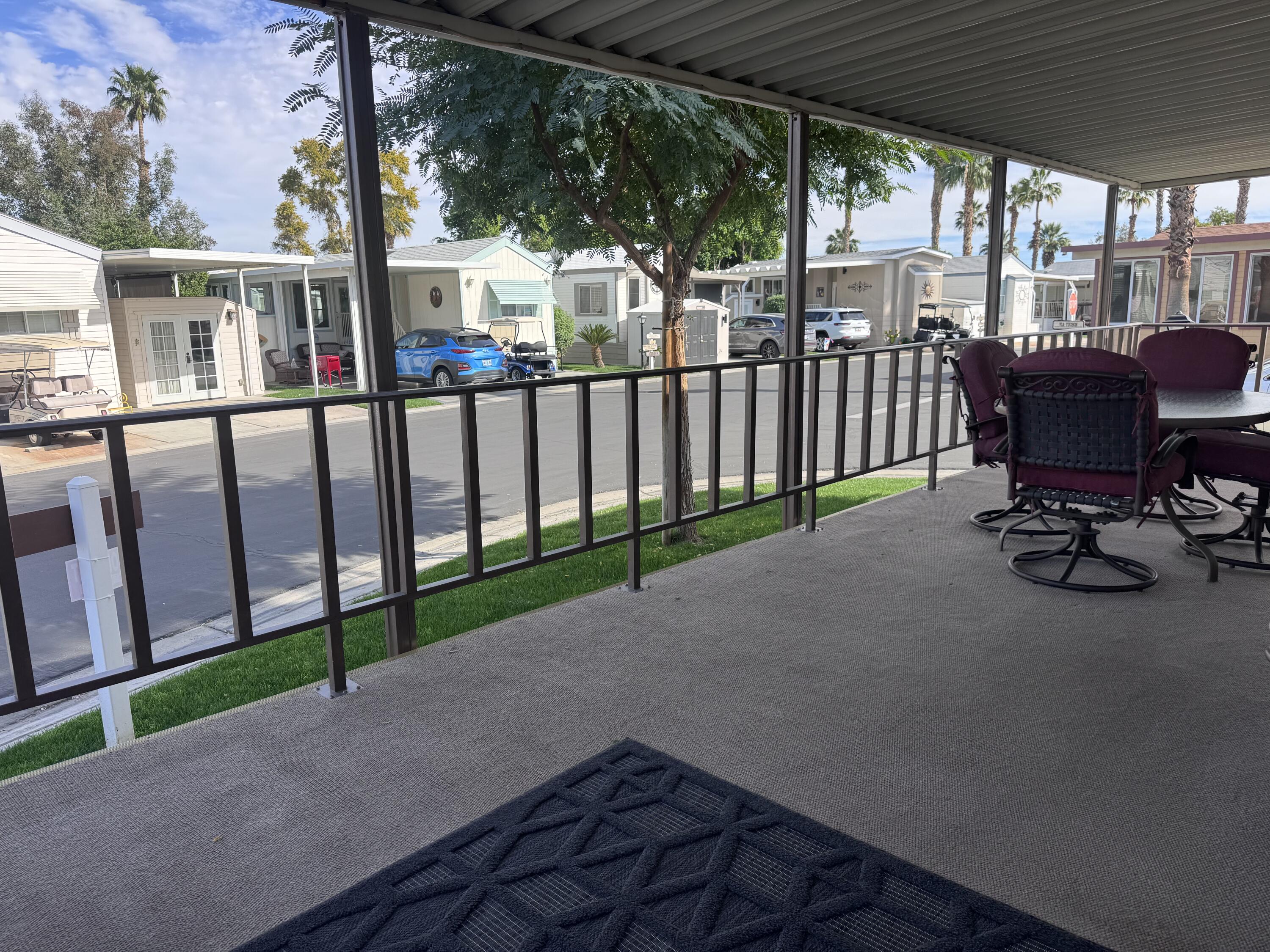 84136 Ave 44, Unit 178 Indio, CA 92203 - Photo 7 of 23 a view of a deck with table and chairs and wooden fence
