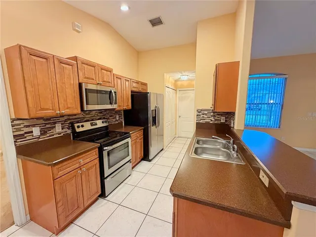 a kitchen with stainless steel appliances granite countertop a stove a sink and a microwave