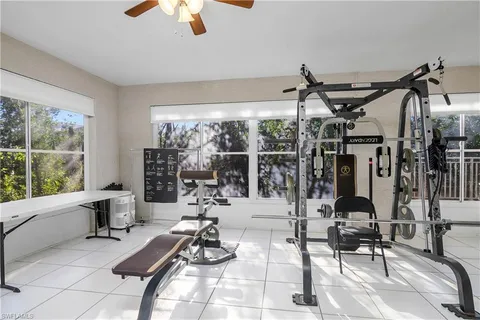 a room with gym equipment and large windows