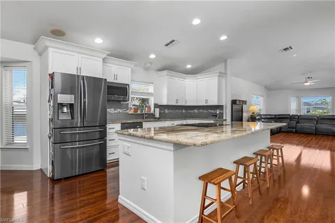 a kitchen with stainless steel appliances granite countertop a refrigerator and a stove top oven