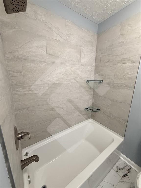 4502 Alder Lane Powder Springs, GA 30127 - Photo 26 of 64 a bath tub sitting next to a white sink and vanity