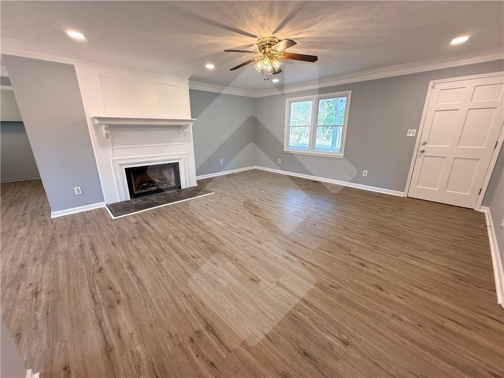 4502 Alder Lane Powder Springs, GA 30127 - Photo 6 of 64 an empty room with windows fireplace and a kitchen view